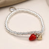 Silver plated bead stretch bracelet with a red enamel strawberry and faux gold plated heart charm